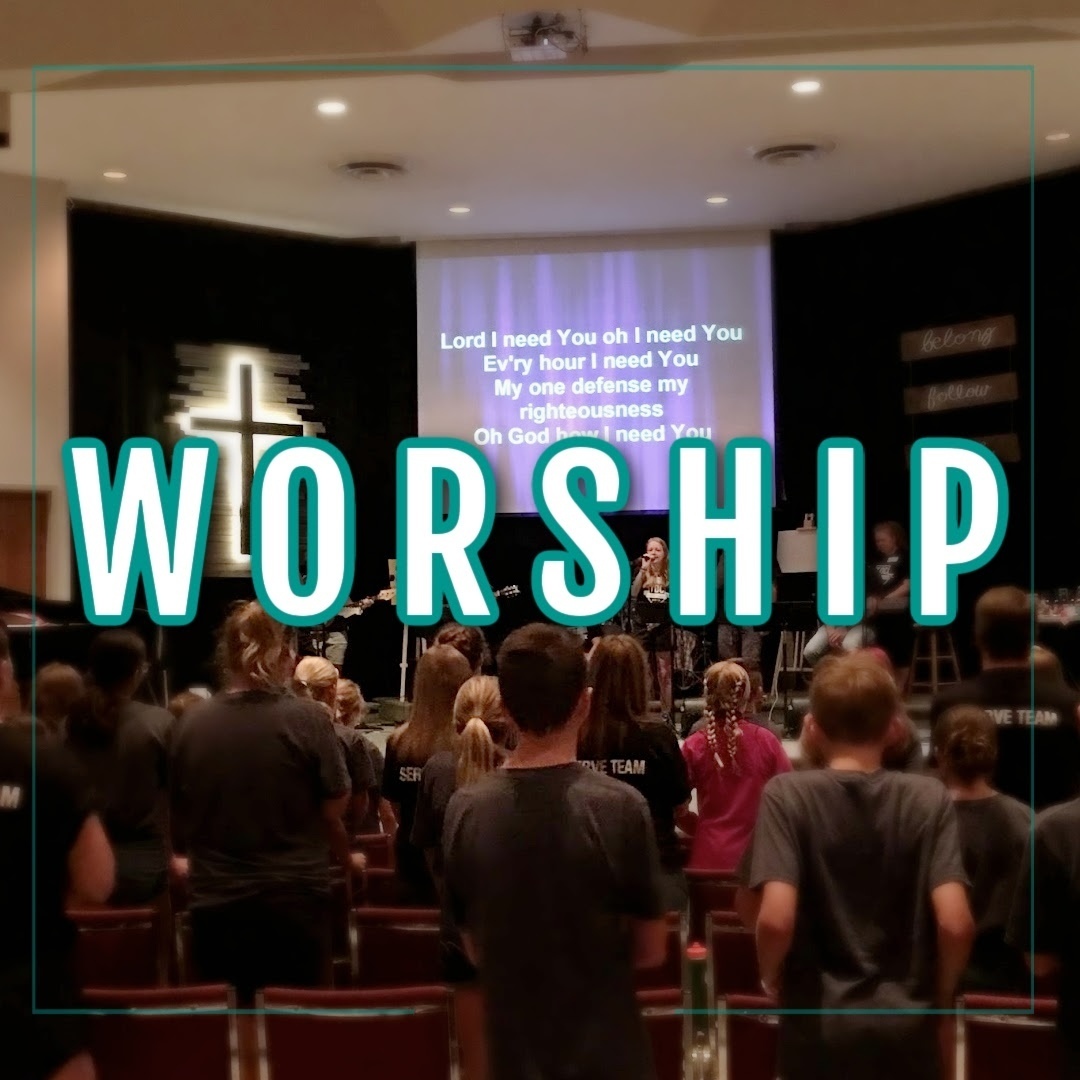 people in a gym worshipping with teal and white lettering