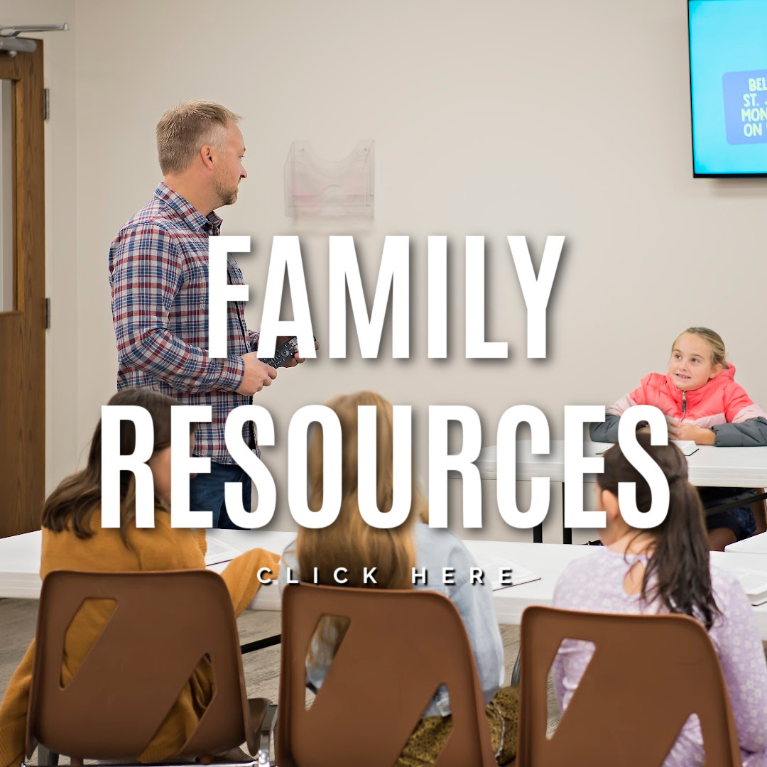 man talking to a group of children white lettering